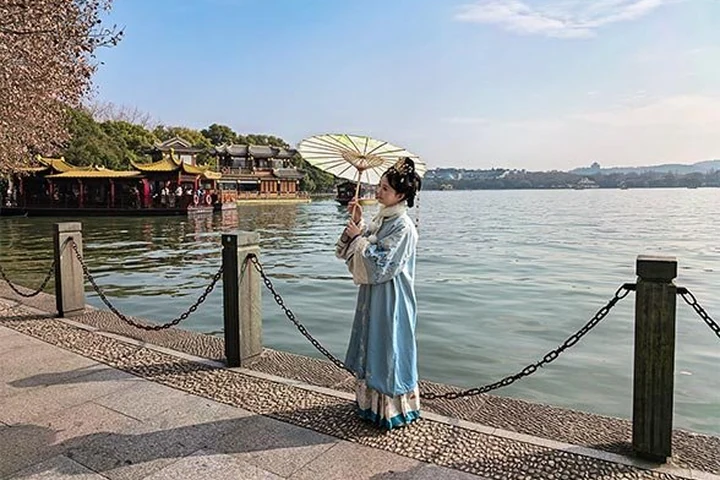 A visitor photographing West Lake in Hangzhou
