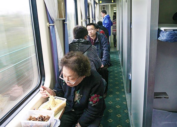 A Chinese Passenger is Eating Instant Noodles